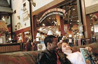 Fred Lyons, left and Jessica Rogers, both from Zion, Ill, relax on a sofa in front of a fireplace at the entrance to Bass Pro Shops Outdoor World in Gurnee, Ill. A Bass Pro Shops coming to the Ameriplex at the Port in Portage has already lured Cracker Barrel and LongHorn Steakhouse restaurants and is driving up business interest in the area at a "phenomenal" rate, developers said. Natalie Battaglia | The Times