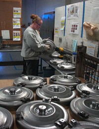 Melinda Stackhouse inspects torque converter covers made for General Motors at Multi-Plex Inc. in Howe. Multi-Plex supplies parts to Japanese carmakers Honda and Nissan. 
Dean Musser Jr./The Journal Gazette 