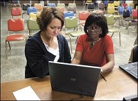 Stephanie Lacy (right) with JobSource helps laid off Guide employee Patricia Teachnor sign up for her unemployment benefits Wednesday at UAW Local 663. Don Knight / The Herald Bulletin