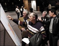 Steve McNutt points to his 135 acre farm that is located in the study area for the proposed Indiana Commerce Connector as he talks to Joseph A. Gustin, deputy commissioner of public-private partnerships for INDOT, after an INDOT meeting at Reardon Auditorium Thursday. Don Knight / The Herald Bulletin