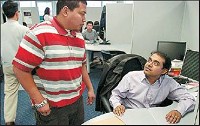 Senior software engineer Nasif Akand, right, consults with network administrator Shahreel Bujang at LHP Software, which plans to create 320 high-tech jobs by 2011. The Republic photo by Andrew Laker