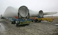 Huge blades for wind turbines sit on oversized trailers in Benton County. The area west of Earl Park is now dotted with the giant turbines. Journal &amp; Courier file photo