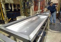 Luke Hall runs casket tops on the production line at Astral Industries in Lynn. (Palladium-Item photo by Steve Koger)