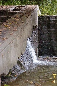 Water leaks out of the east side of Broad Ripple Dam. A $2 million repair is planned by city’s Department of Waterworks as part of rate case. (IBJ Photo/Robin Jerstad)