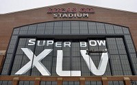 A crew finishes attaching the "V" in the Roman numeral XLVI on Lucas Oil Stadium in preparation for Super Bowl XLVI in Indianapolis. Herald Bulletin photo by Joseph C. Garza