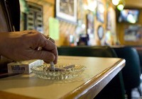 A patron puts out a cigarette at Traditions Restaurant and Pub in downtown Highland Thursday afternoon. | Jeffrey D. Nicholls~Sun-Times Media