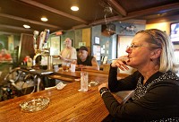 Debbie Morgan smokes a cigarette at the bar inside Frank's Place restaurant in South Bend on Thursday. (South Bend Tribune/ROBERT FRANKLIN)