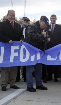 Indiana Gov. Mitch Daniels cuts the official "I-69 Open for Business" ribbon Monday. Staff photo by Sam Owens