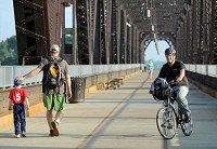 Eric Willey, Jeffersonville, pedals down the Big Four Bridge on his way to work in Louisville Friday morning as part of the national "Bike to Work Day." Willey, who has been biking to work off and on for six months, is happy to finally be off the Clark Memorial Bridge.&nbsp; Staff photo by Tyler Stewart
