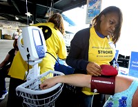 Methodist Hospital's nurse Ilena Green uses a large blood pressure cuff to check blood pressure recently during Methodist's annual Strike Out Stroke event. It was a stroke awareness event for the community, during a RailCats game at the US SteelYard. Staff photo by John Luke