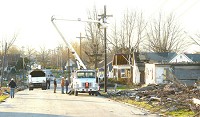 Utility crews put up new electrical lines along the hard hit 300 block of Sycamore Street following a tornado last November. While the utilities were quickly restored some residents are still putting their property back together and getting repairs done as part of the Long Term Recovery Program. Staff photo by Kelly Overton