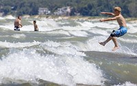 Seven-year-old Jacob Rypma leaps into choppy Lake Michigan waters on Thursday at WashingtonPark beach in Michigan City. SBT Photo/ROBERT FRANKLIN)