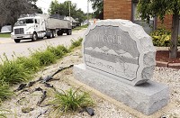 A history that runs deep: A coal truck drives by a monument dedicated to the 100th anniversary of the town of Dugger in the small Sullivan County town. Like the images on the monument depict, Dugger has a rich history of coal mining. Photo by Joseph C. Garza, Tribune-Star