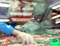 PORK SALES: Rita Kennedy-Brown selects some ribs for a customer at White's Meat Market. Kelly Lafferty | Kokomo Tribune