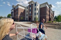 Emile Davis, right, 21 and of Indianapolis, pulls a cart that contains her belongings with some help from her mother, Hilary Davis-Reed, to Reeve Hall on the Indiana State University campus. Staff photo by Joseph C. Garza