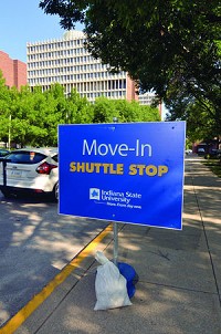 A sign lets students who are moving back to campus know that they can board a shuttle bus at a spot on Fifth Street on the Indiana State University campus. Staff photo by Joseph C. Garza
