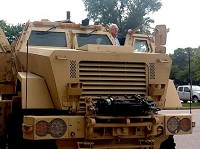 Munster Clerk-Treasurer David Shafer poses in the Town of Munster's new MRAP Caiman 6x6 vehicle Tuesday afternoon as former Councilman Mike Mellon listens to an explanation of it. The vehicle is the third one secured in District 1 and will be used in Jasper, Newton, Porter, LaPorte and Lake counties. | Michelle L. Quinn~for Sun-Times Media