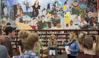 Bloomington High School North librarian Kathy Loser gives a tour of the library to freshmen at the school. The mural was created by two students in 1994 and represents six genres of literature.&nbsp;David Snodgress | Herald-Times