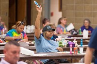 Michigan City resident Nikia Hancock raises her hand after getting a bingo on Monday during bingo night at Nativity of our Savior church in Portage. | Kyle Telechan/For Sun-Times Media