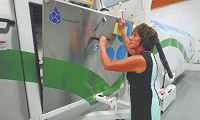 Becky Molnar, organizational development specialist at Hancock Regional Hospital, checks one of two ozone-utilizing waste treatment machines at the new 03 PureMed plant. (Tom Russo / Daily Reporter)