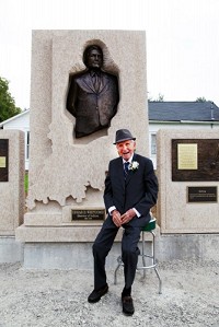 Former Indiana Governor Edgar Whitcomb sits in front of a monument that was created in his honor near his childhood home in Hayden. The monument was unveiled during Hayden's Pioneer Days on Saturday. 
