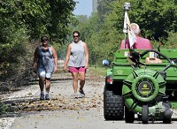 Hillary Heishman and her mother Karyn Harmon don't let even a leaf blower stop them from walking the Panhandle Pathway trail. Harmon is visiting from New Mexico. Staff photo by Steve Summers