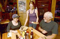Marlene Hopton and David Dever, both of Terre Haute, have their meals delivered to them by Thirty-Six Saloon waitress, Cassidy White, on Friday. CNHI photo by Joseph C. Garza, Tribune-Star