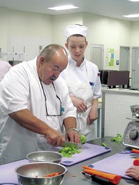 Chef Peter Tzeschlock shows East Noble High School junior Katelyn Meyer how to cut celery efficiently. Photo by Amy Oberlin