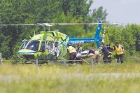 Fire-rescue personnel load one of the two air ambulances that were called to the scene of a two-vehicle accident in the northbound lanes of Interstate 69 near Exit 234 that killed one and injured six others on Sept. 14. Staff photo by John P. Cleary