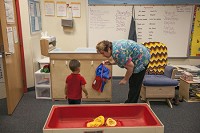 Tracy Baber helps a student at a Head Start classroom for 3-year-olds at the Lafayette Early Childhood Center in South Bend. Local educators and others who&rsquo;ve been laying the groundwork to expand preschool programs that serve low-income students, such as Head Start, are disappointed that Gov. Mike Pence did not pursue a federal grant that could have brought $80 million into the state over four years for pre-k education.&nbsp;SBT Photo/SANTIAGO FLORES