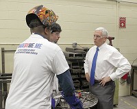 Gov. Mike Pence, right, talks to students in the Anthis Career Center&rsquo;s welding lab. Staff photo by Barry Rochford