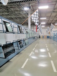 The entrance to the factory floor at Carlex Glass shows the company&rsquo;s &ldquo;Wall of Fame&rdquo; of automotive glass, including various windshields.