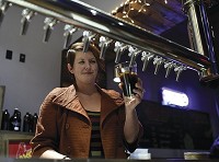 CRAFT BEER: Shanna Henry, Flat 12 Bierwerks facility manager, pours a beer at the brewery&rsquo;s Jeffersonville location recently. It offers several options, including pints, growlers and flights in-house. CNHI Staff photo by Tyler Stewart