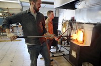 Master glass blower Eli Zilke, left, and glass blower Bryan Lee work on a new decorative vessel at Hot Shop Valpo, a new glass blowing business in Valparaiso. Staff photo by John J. Watkins