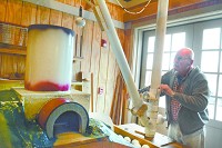 Dan McCain, president of the Wabash &amp; Erie Canal Association, operates the new replica of a crane-like device, called a gin pole, that was used to load limestone rocks into kilns. Young visitors to the museum will be able to operate the device soon. Staff photo by J. Kyle Keener