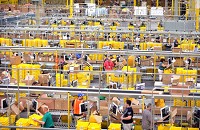 Employees at the receiving and processing station collect and process items to be housed in the pick library to fill orders at the Amazon Fulfillment Center in Jeffersonville recently. In total, the center employs around 2,500 workers to receive, pull inventory, process and ship orders throughout the day. Staff file photo