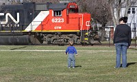 A child watches in fascination while a Canadian National freight train rumbles south on the EJ&amp;E line past Griffith's Tot Park. Canadian National has advanced its competitive position by acquiring and improving the EJ&amp;E line around Chicago. Other railroads are investigating similar bypass routes. Staff photo by John Luke