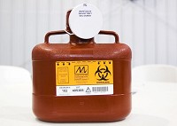 A biohazard container for the temporary disposal of needles and other sharp objects is pictured at Grace Covenant Church of God in downtown Austin following an HIV/AIDS training for local and state law enforcement and jail staff by the Midwest AIDS Training and Education Center on Wednesday afternoon. State health officials are working to equip local law enforcement with these containers and other safety equipment, such as stick-resistant gloves, in response to the current HIV outbreak in Scott County. Staff photo by Christopher Fryer