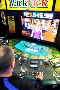 Josh Jones, Muncie, plays blackjack against the video dealer at one of the 19 electronic table games inside Hoosier Park Racing &amp; Casino. Staff photo by John P. Cleary