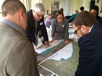 Mark Bouman, left center, president of Calumet Heritage Partnership, looks over a map of the Calumet Region with participants at the Calumet Heritage Summit Tuesday at Chicago's South Shore Cultural Center. Staff photo by Lauri Harvey Keagle
