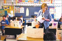 MOVING ON: Long time teacher Marcia Smith works with students in her second-grade classroom at Western Primary School. The school had the highest retention rate going into the 2013-14 school year among area institutions. Staff photo by Tim Bath