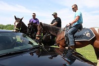 From left: police officers Jason Maynard, Guy Trobaugh, and Austin McClain bring their horses near the police car so their horse could get used to its lights and sirens. Friday, May 8, 2015. Kelly Lafferty Gerber | Kokomo Tribune