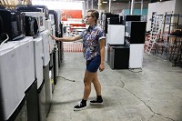 Annabella Habegger, a student in the Indiana University Internship Program in Sustainability, shows some of the appliances that will be sold during the Hoosier to Hoosier sale Aug. 22. Staff photo by Jeremy Hogan