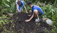 Bryce Anderson spreads the mulch at the Unity Gardens at LaSalle Square during garden camp in June. The Blue Zones Project encourages community gardens and activities that get children outdoors and introduce healthy food options. SBT Photo/SANTIAGO FLORES