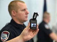 Jeffersonville Police Cpl. Todd Wilson holds a body camera that his his department's police officers started wearing in May. The department started using the cameras before finalizing the policy on when the recordings will be released to the public. Staff photo by Tyler Stewart