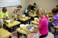Aiden Seifert of Jasper, 9, left, Marianna Green of Jasper, 11, Olivia Rothgerber of Santa Claus, 13, and Cloey Metzger of Jasper, 13, worked on their wheel throwing technique during a pottery class for middle school students on July 7 in Jasper. The class was part of the arts center&rsquo;s summer ARTventures program. Staff photo by Ariana van den Akker
