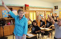 Luanne Grisafi, a second-grade teacher at Our Lady of Grace Elementary School in Highland, demonstrates the proper angle of an "imaginary writing instrument" during an exercise with her class to help students master proper penmanship for the letter A. Staff photo by Damian Rico