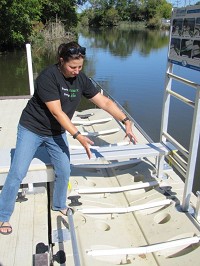 Maggie Byrne, with the Indiana Department of Natural Resources, illustrates how to use the new handicapped accessible launch for kayaks and canoes at Hansen Park along Trail Creek in Michigan City. Staff photo by Stan Maddux
