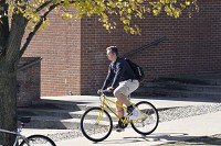 Taylor University freshman Tanner Huber heads to class on one of the yellow Taylor Taxi bicycles after lunch Wednesday at the Hodson Dining Commons. Staff photo by Jeff Morehead