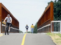 People cross the Erie-Lackawanna Trail hike and bike bridge over 167th Street, Columbia and Southeastern avenues in Hammond, shortly after its opening in July. The trail is now designated as a U.S. Bicycle Route, similar to a U.S. interstate highway -- but for bicycles rather than cars. Staff photo by Stephanie Dowell